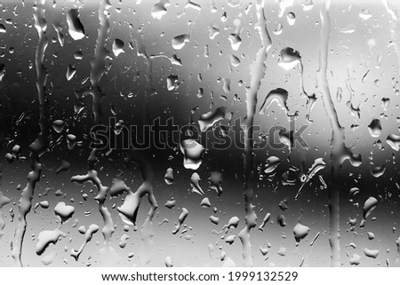 Streams of raindrops on window glass