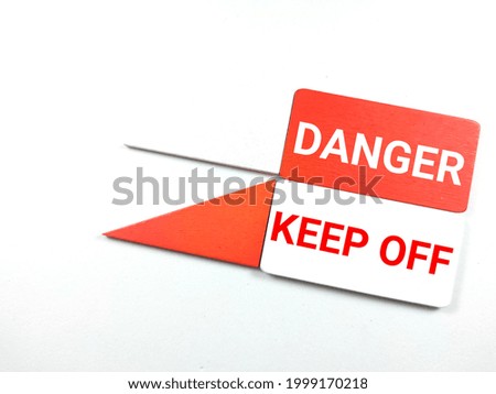 Colorful wooden board with text DANGER KEEP OFF on white background.