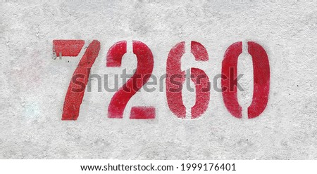 Red Number 7260 on the white wall. Spray paint. Number seven thousand two hundred and sixty.