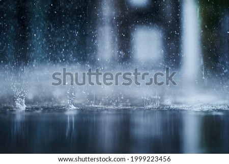 heavy raining make many small splash crown from water droplets drop down to the concrete floor in blue tone color scene 
