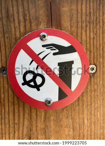 sign - forbidden of throwing pretzel over the wall no feeding