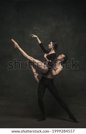 Passion. Young beautiful graceful woman and man, ballet dancers in art performance dancing isolated over dark background. Concept of love, feelings, beauty, art and theater.