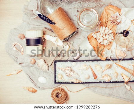 a lot of sea theme in mess like shells, candles, perfume, girl stuff on linen, pretty textured post card view vintage close up