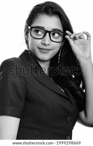 Studio shot of young beautiful Indian businesswoman isolated against white background in black and white
