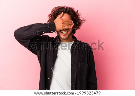 Young caucasian man isolated on pink bakcground covers eyes with hands, smiles broadly waiting for a surprise. Royalty-Free Stock Photo #1999323479