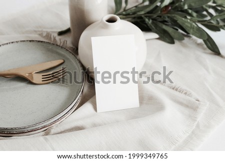 Card mockup on empty modern minimal table place setting neutral beige color .  Space for text. Sheet card template, wedding invitation, cutlery, Scandinavian style.