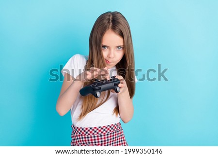 Photo of cute brown hair small girl playstation wear white t-shirt isolated on blue color background