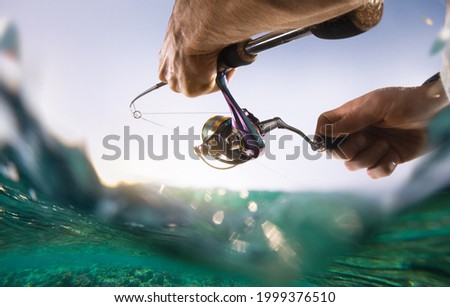 Fishing blurred background. Fisherman with spinning on the sea. Royalty-Free Stock Photo #1999376510