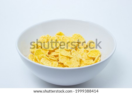 Plate with cornflakes on a white background. Healthy and tasty breakfast.