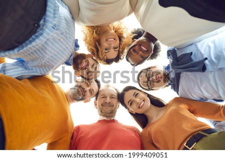 Diverse dream team united like one family. Group portrait of happy positive mixed race people, male and female business partners or colleagues, huddling touching heads in work meeting, bottom view Royalty-Free Stock Photo #1999409051