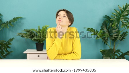 Portrait of young thinking pondering woman having idea moment pointing finger up.Smiling happy girl showing eureka gesture. 