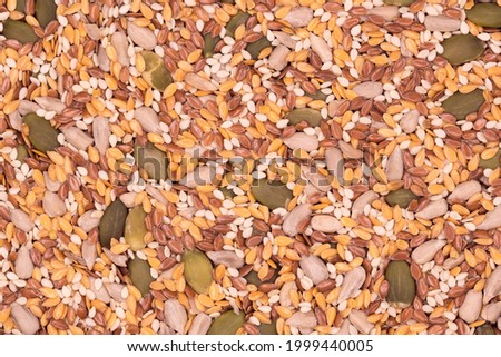 Surface of a flat seeds with sesame, flax, pumpkin and sunflower seeds, top view close-up, background