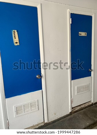 Men and women rest  room with crooked sign