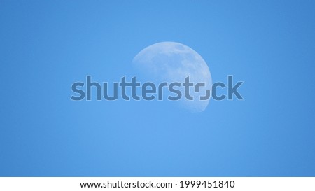 Daytime moon on a blue sky background