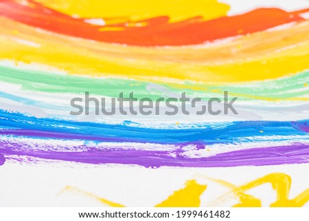 Fragment of children's drawing of rainbow on white sheet of paper. Top view