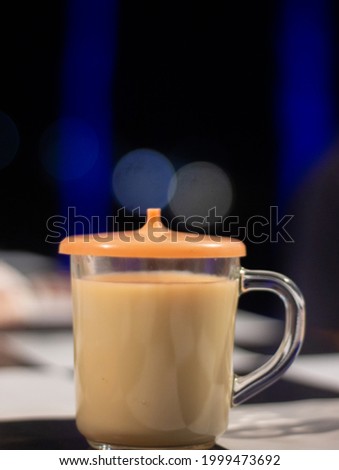 defocused abstract background of a glass of ginger milk drink at a cafe table with a blur background and a black and white cover.