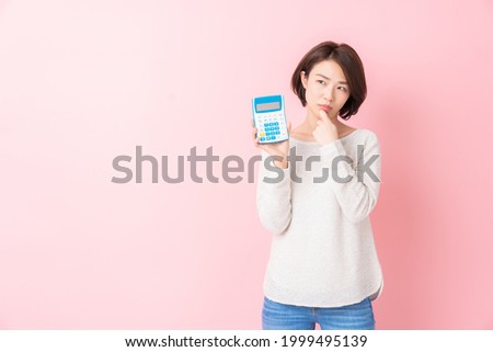 Woman of thinking having an electronic calculator