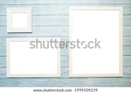 White frames for a picture with copy space on a wooden turquoise background for mockup