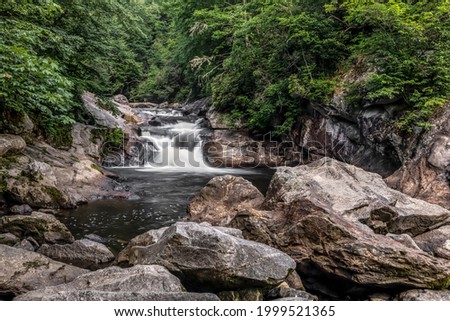 A popular swimming hole, Bust Your Butt Falls is a small waterfall on the Cullasaja River in Nantahala National Forest near the town of Highlands in the beautiful mountains of western North Carolina. Royalty-Free Stock Photo #1999521365