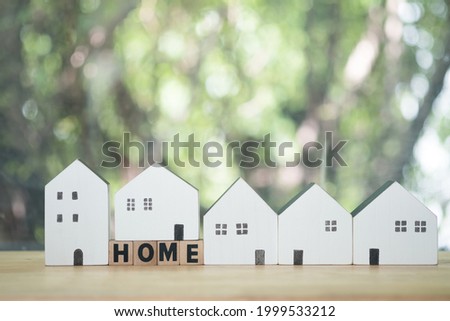 A lot of wood white of house and wooden blocks with the word home on the table. The concept of real estate and property.