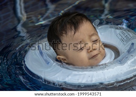 Local lifestyle footage of Asian Chinese 10 month baby boy first time playing on swimming pool