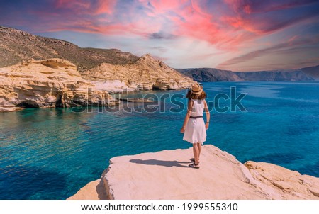 A young woman in a white dress looking at the sea in Rodalquilar in Cabo de Gata on a beautiful summer day, Almería. Mediterranean sea, spain Royalty-Free Stock Photo #1999555340