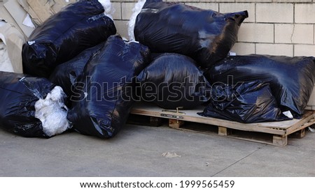 black garbage bags stacked on the floor