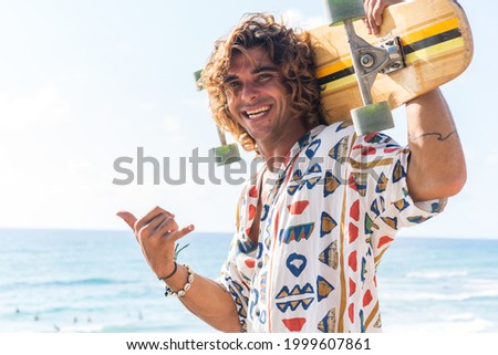 Young caucasian man practicing longboard on the beach