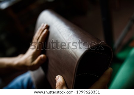 A leather craftsman works in a workshop Royalty-Free Stock Photo #1999628351