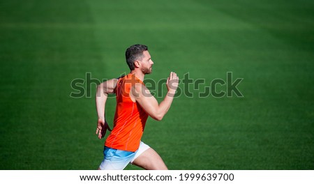 energetic man on running track. sporty runner. stamina. sport and endurance. outdoor stadium sprint. Royalty-Free Stock Photo #1999639700