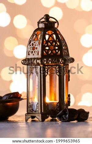 Muslim lamp and dates on light background with blurred lights Royalty-Free Stock Photo #1999653965