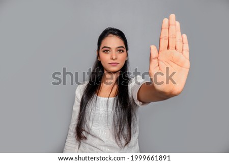 Young beautiful woman wearing white dress kurti doing stop sign with palm of the hand. Warning expression with negative and serious gesture on the face.