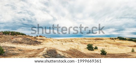 Sand dunes of the Curonian Spit in the cloudy weather with the sky covered with clouds