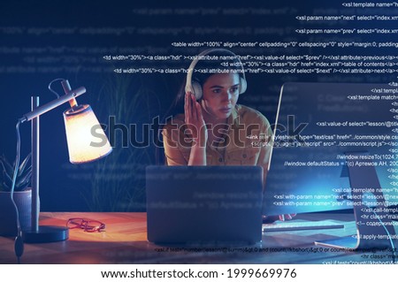 Programmer with headphones working in office at night