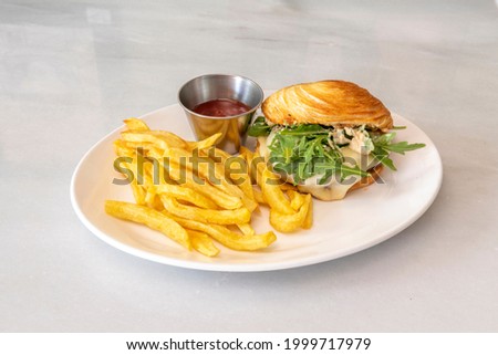 French-style duck meat burger with croissant bread, side of French fries and ketchup