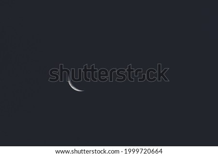 crescent moon in the night sky shot with subtle crushed black editing
