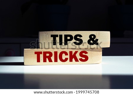 Tips and tricks symbol. Wooden blocks with words 'Tips and tricks'. businessman hand. Business, tips and tricks concept. Copy space.