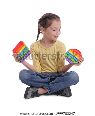 Little girl with pop it fidget toys on white background