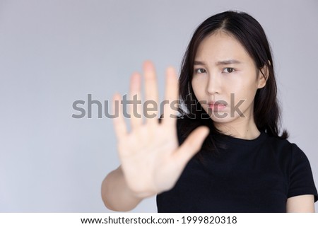 woman saying no with rejecting hand gesture and negative facial expression