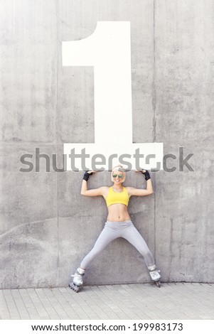 A happy rollerblader and number one on a concrete wall