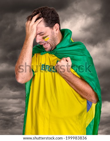 Brazilian soccer fan or supporter crying in the championship or competition or cup.