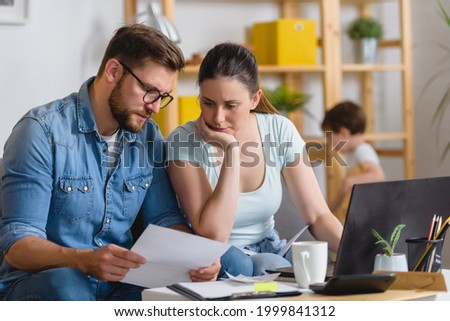 Family with a child having financial problems, doing home budgeting, calculating expenses. Royalty-Free Stock Photo #1999841312