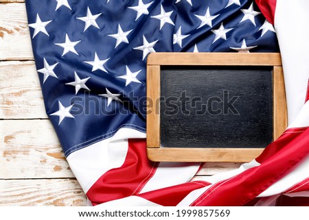 Chalkboard and USA flag on wooden background