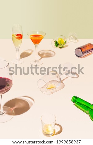 After party retro concept. A table full of  beer bottles of different kind of glasses - wine, cocktail, champagne, vodka full, half full and empty