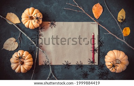Halloween grunge dark blue holiday background, pumpkins, dry branches and orange leaves decorations. Autumn composition frame, party invitation card, flat lay, copy space.
