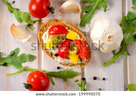 Single bruschetta with pepper,onion and cheese from above on the wooden table 
