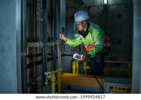 worker service check  elevator. service  engineer work in elevator shaft Royalty-Free Stock Photo #1999924817