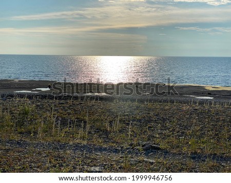 The sun in the ocean and a coastline. The picture is taken from Byxelkrok, in Öland in Sweden.