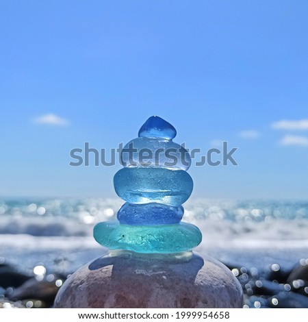 Blue Sea Glass Pyramid on the Background of the Sea Royalty-Free Stock Photo #1999954658