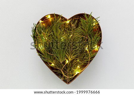 Heart shaped coniferous branches flat lay with festive twincle lights